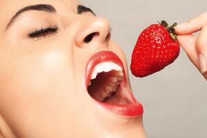 sexy mujer comiendo fresa foto