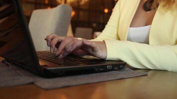 detailopname. mooi bedrijf vrouw met blond haar- in bedrijf kleren typen tekst Aan een mobiel computer zittend Bij een tafel in een cafe. hd. video