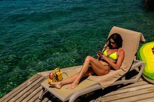 Young sexy girl in a light green bikini on the ocean photo