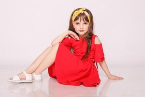 Portrait of a little girl in a red dress on the white background photo