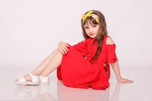 Portrait of a little girl in a red dress on the white background photo