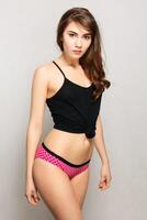 Beautiful young sexy attractive girl in black t-shirt and pink shorts posing photo