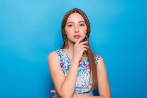 Portrait of happy smiling young beautiful woman in blue casual clothing, over blue background photo