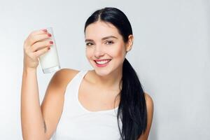 Milk - Woman drinking milk, happy and smiling beautiful young woman photo