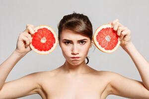 Beauty portrait of a happy woman holding grapefruit photo
