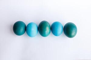 Row of ombre blue Easter eggs isolated on white background photo