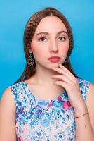 Portrait of happy smiling young beautiful woman in blue casual clothing, over blue background photo