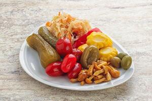 Plate with pickled vegetables and mushrooms photo