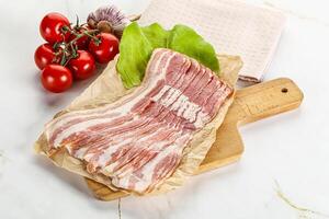 Sliced pork bacon oved board photo