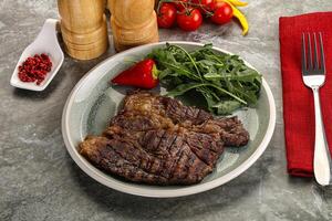 Grilled chuck roll steak with arugula photo