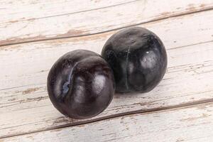 Two ripe sweet black plums photo