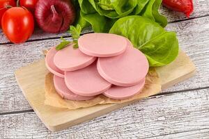 Slices boiled sausages for breakfast photo