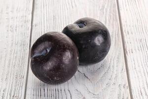 Two ripe sweet black plums photo