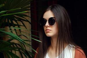 close up portrait young girl in white shirt jeans and sunglasses photo