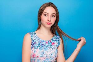 Portrait of happy smiling young beautiful woman in blue casual clothing, over blue background photo