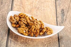 Cracked unshelled walnut in the bowl photo