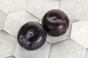 Two ripe sweet black plums photo