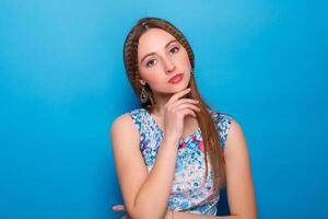 Portrait of happy smiling young beautiful woman in blue casual clothing, over blue background photo