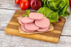 Slices boiled sausages for breakfast photo
