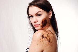 Brunette woman cleans the skin of the body coffee scrub photo