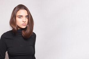 Confident female wearing black turtleneck sweater while posing photo