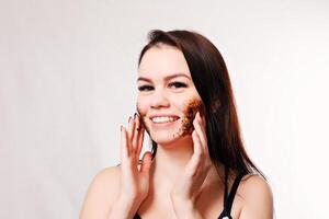 Brunette cleanses the skin with coffee scrub photo