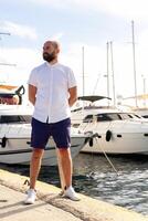 Photo of handsome man with luxury yacht in port