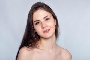 Beautiful Young Woman with Clean Fresh Skin touch own face . photo