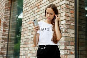 Young woman with headphones dangling on her mobile phone photo