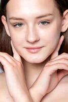 Beautiful Young Woman with Clean Fresh Skin touch own face . photo