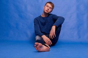 retrato de un adulto hermoso elegante pacífico hombre en un azul suéter foto