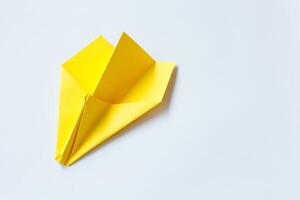 Yellow origami plane on a white background. photo