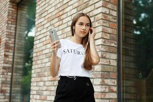 Young woman with headphones dangling on her mobile phone photo