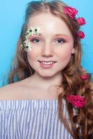 Positive girl. Little girl with daisies in her hands on a blue background. photo