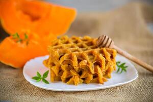 sweet baked pumpkin waffles with honey in a plate photo
