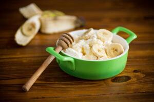 homemade cottage cheese in a bowl with bananas and honey photo