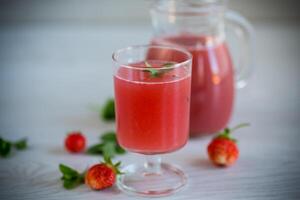 Cold summer strawberry kvass with mint in a glass photo