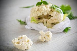 inflorescences of small cauliflower on a light wooden table photo