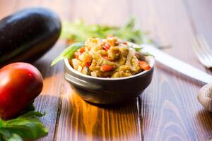 berenjena frito salteado con otro vegetales en un plato foto