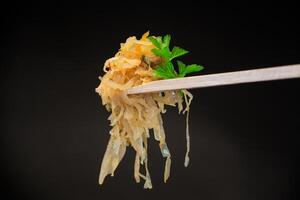 cabbage stewed with spices and carrots on a wooden fork photo