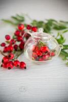 ripe red rose hips on a wooden table photo