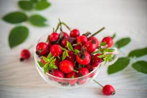 ripe red rose hips on a wooden table photo