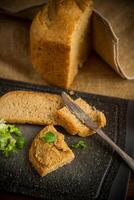 homemade meat pate with bread on a wooden table photo