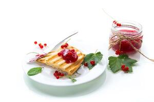 fried bread croutons for breakfast with redcurrant jam in a plate with berries photo