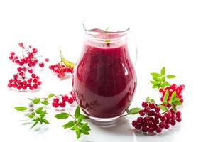 freshly squeezed thick natural juice with pulp from ripe red viburnum in a decanter photo