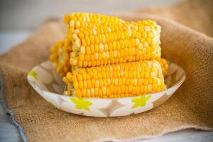 a few heads of boiled corn on a plate photo