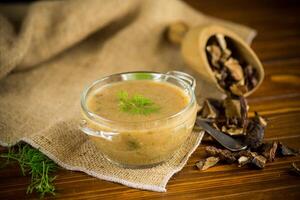 hot homemade vegetable vegetarian soup with dried mushrooms in a glass bowl photo