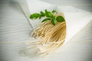 homemade thin dried egg noodles in paper bag with basil photo