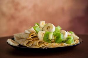 cocido Delgado panqueques con bananas y kiwi foto