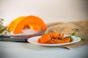 sweet baked grilled pumpkin with seeds in a plate photo